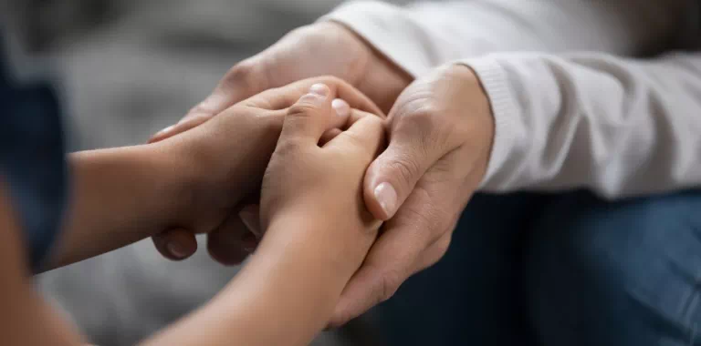 Ręce dziecka trzymane przez ojca